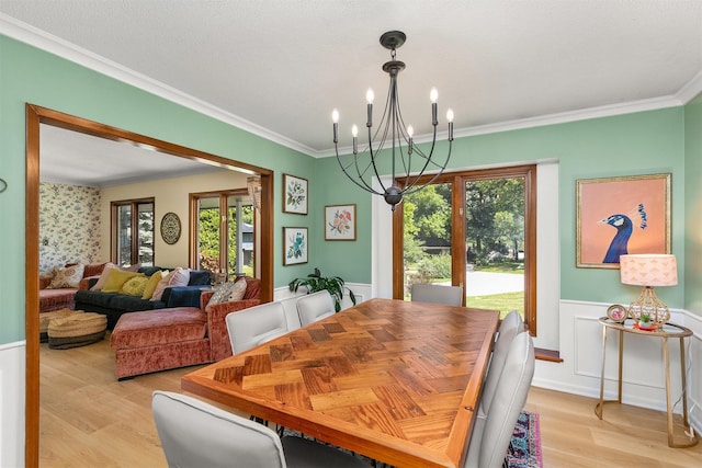 10438 Donna Bella Cir, Clive, IA 50325 - dining space featuring healthy amount of natural light, wainscoting, light wood finished floors, a chandelier, and ornamental molding