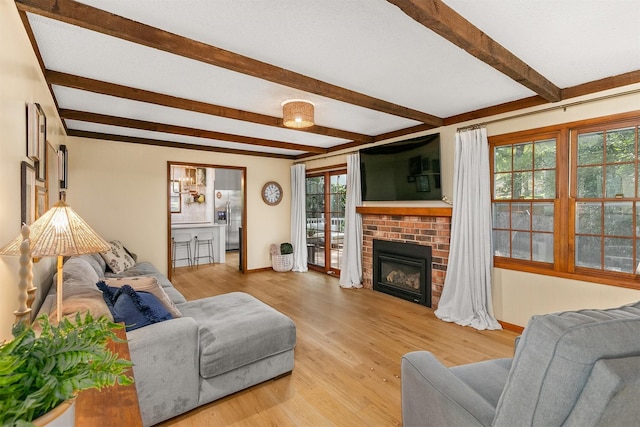 10438 Donna Bella Cir, Clive, IA 50325 - living room featuring beam ceiling, light wood finished floors, and a brick fireplace