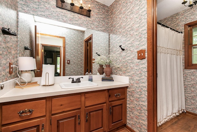 10438 Donna Bella Cir, Clive, IA 50325 - full bath with wood finished floors, vanity, wallpapered walls, and a shower with curtain