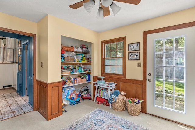 10438 Donna Bella Cir, Clive, IA 50325 - doorway to outside with a ceiling fan, carpet, and a wainscoted wall