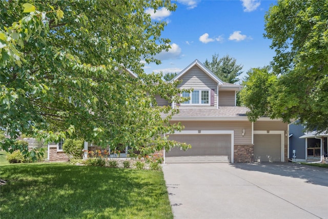 303 Trevor Ct, Norwalk, IA 50211 - view of front of home with a garage, concrete driveway, a front yard, stone siding, and a shingled roof