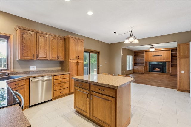 303 Trevor Ct, Norwalk, IA 50211 - kitchen with dishwasher, a lit fireplace, a center island, brown cabinetry, and recessed lighting