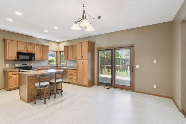 303 Trevor Ct, Norwalk, IA 50211 - kitchen with stainless steel appliances, healthy amount of natural light, light countertops, a breakfast bar, and recessed lighting