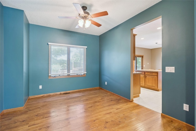 303 Trevor Ct, Norwalk, IA 50211 - empty room featuring healthy amount of natural light, light wood-type flooring, and ceiling fan