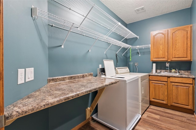 303 Trevor Ct, Norwalk, IA 50211 - washroom featuring washing machine and clothes dryer, light wood finished floors, and cabinet space