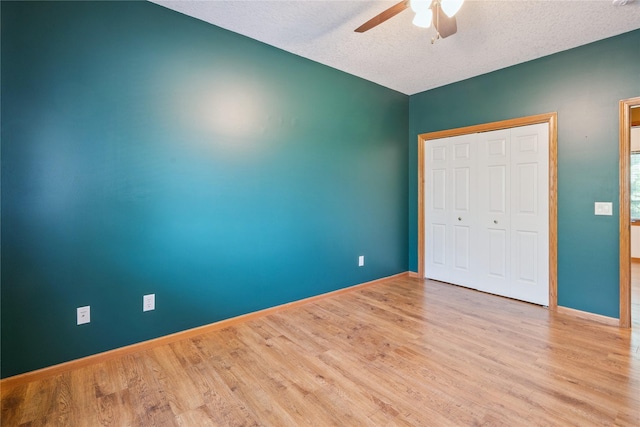 303 Trevor Ct, Norwalk, IA 50211 - unfurnished bedroom featuring wood finished floors, a textured ceiling, a closet, and a ceiling fan