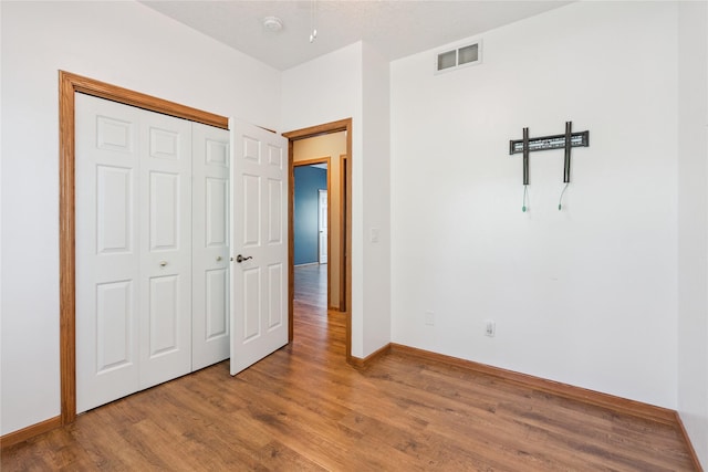 303 Trevor Ct, Norwalk, IA 50211 - unfurnished bedroom featuring wood finished floors and a closet
