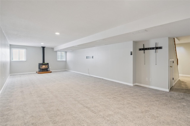 303 Trevor Ct, Norwalk, IA 50211 - below grade area with a wood stove, carpet floors, and recessed lighting