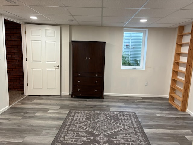 3909 75th St, Urbandale, IA 50322 - unfurnished bedroom featuring wood finished floors, a drop ceiling, recessed lighting, and brick wall