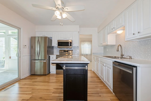 4511 67th St, Urbandale, IA 50322 - kitchen with appliances with stainless steel finishes, light countertops, white cabinets, and wainscoting