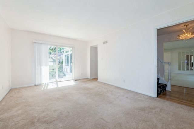4511 67th St, Urbandale, IA 50322 - carpeted empty room featuring stairs and a chandelier