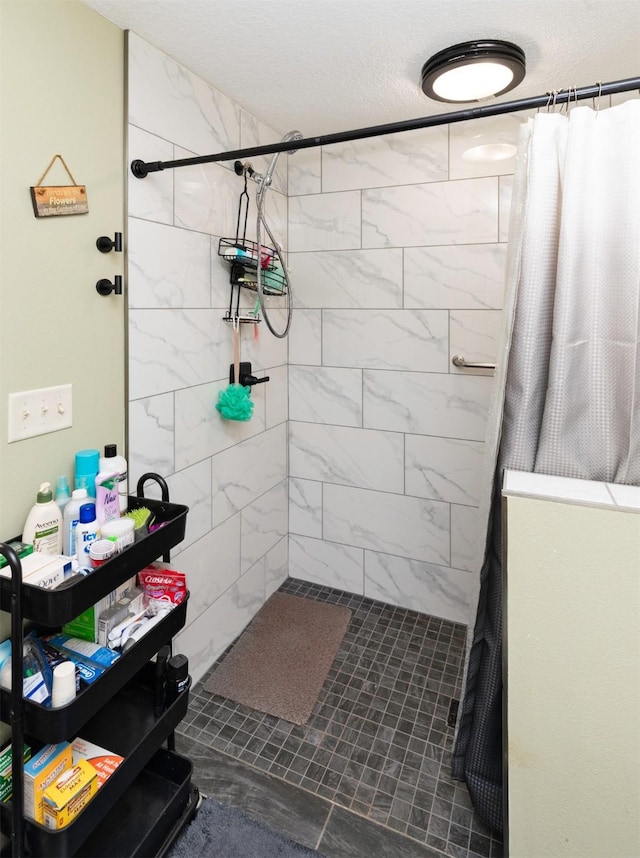 1695 Pease Dr, Pleasant Hill, IA 50327 - bathroom featuring a tile shower and a textured ceiling