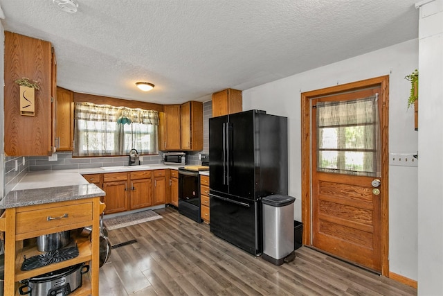 404 W Salem Ave, Indianola, IA 50125 - kitchen featuring black appliances, brown cabinets, dark wood-style flooring, a textured ceiling, and backsplash