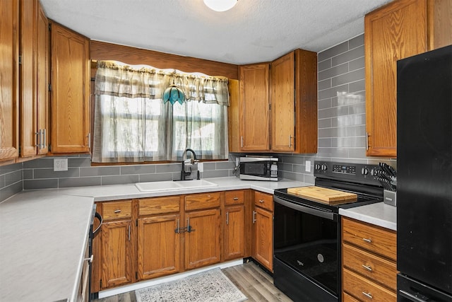 404 W Salem Ave, Indianola, IA 50125 - kitchen featuring black appliances, brown cabinets, decorative backsplash, light countertops, and a textured ceiling