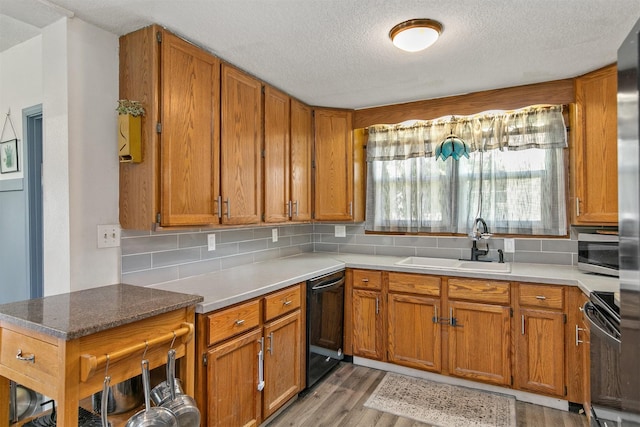 404 W Salem Ave, Indianola, IA 50125 - kitchen with black dishwasher, stove, a textured ceiling, light wood-type flooring, and brown cabinetry