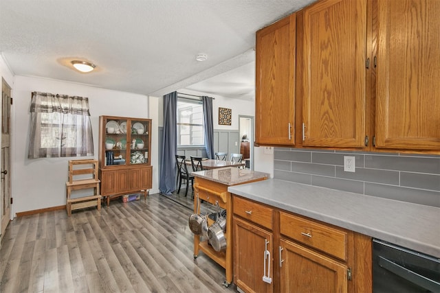 404 W Salem Ave, Indianola, IA 50125 - kitchen featuring light countertops, tasteful backsplash, brown cabinets, light wood-type flooring, and a textured ceiling