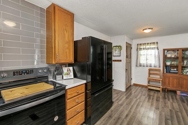 404 W Salem Ave, Indianola, IA 50125 - kitchen with black appliances, wood finished floors, brown cabinets, a textured ceiling, and light countertops