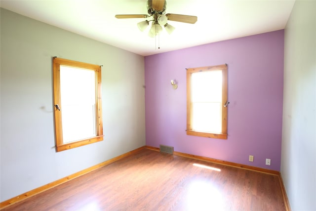 24388 250th St, Eldora, IA 50627 - empty room featuring wood finished floors, healthy amount of natural light, and ceiling fan