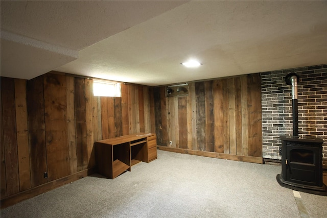 24388 250th St, Eldora, IA 50627 - below grade area with a wood stove, carpet, and wood walls
