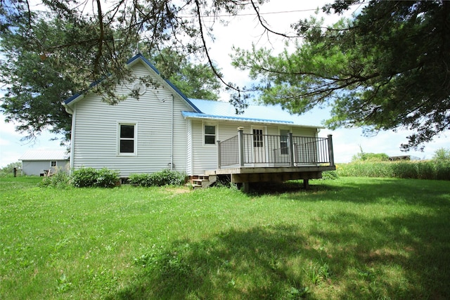 24388 250th St, Eldora, IA 50627 - back of property with a deck, a lawn, and a metal roof