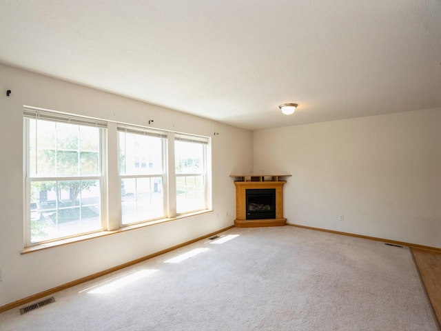 1246 SE Village View Ln, Ankeny, IA 50021 - unfurnished living room with a fireplace with raised hearth and light colored carpet