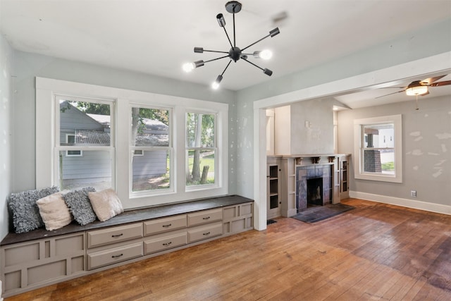 3907 50th St, Des Moines, IA 50310 - unfurnished living room with light wood finished floors, a chandelier, and a tiled fireplace