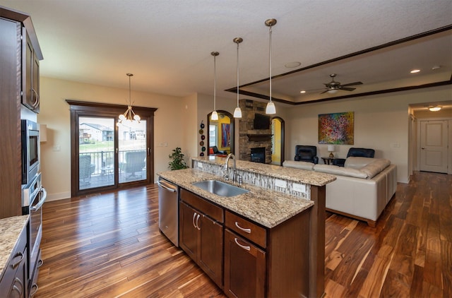 2100 NW Prairie Creek Dr, Grimes, IA 50111 - kitchen featuring a stone fireplace, open floor plan, appliances with stainless steel finishes, an island with sink, and dark wood-type flooring