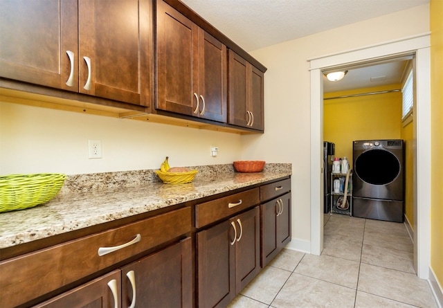 2100 NW Prairie Creek Dr, Grimes, IA 50111 - kitchen with washer / dryer, light tile patterned floors, light stone counters, and dark brown cabinets