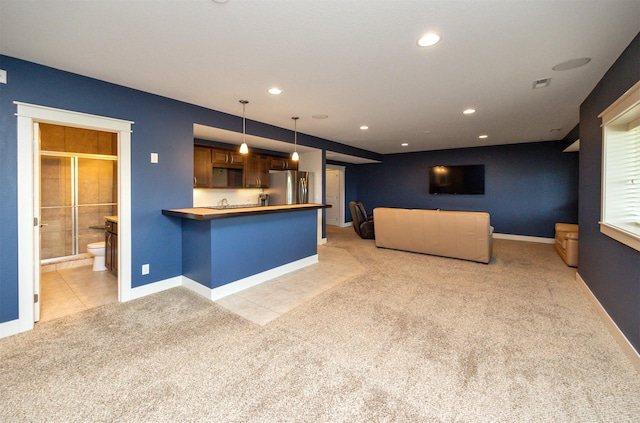 2100 NW Prairie Creek Dr, Grimes, IA 50111 - kitchen with freestanding refrigerator, light colored carpet, hanging light fixtures, recessed lighting, and a peninsula