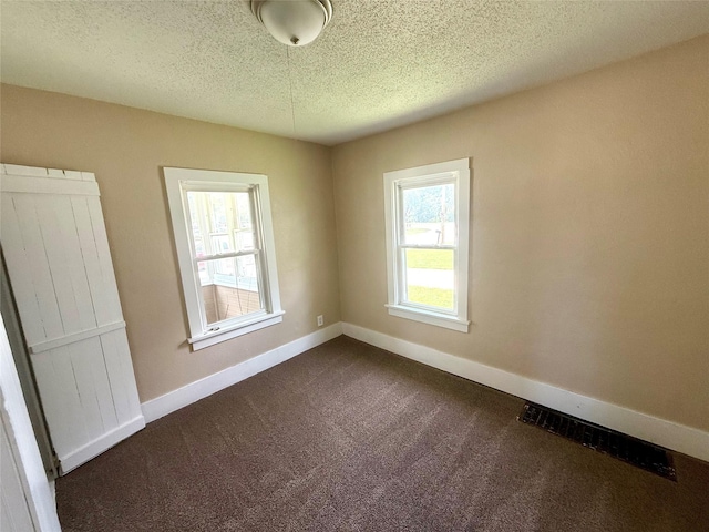 906 Rittenhouse St, Des Moines, IA 50315 - spare room with dark carpet and a textured ceiling