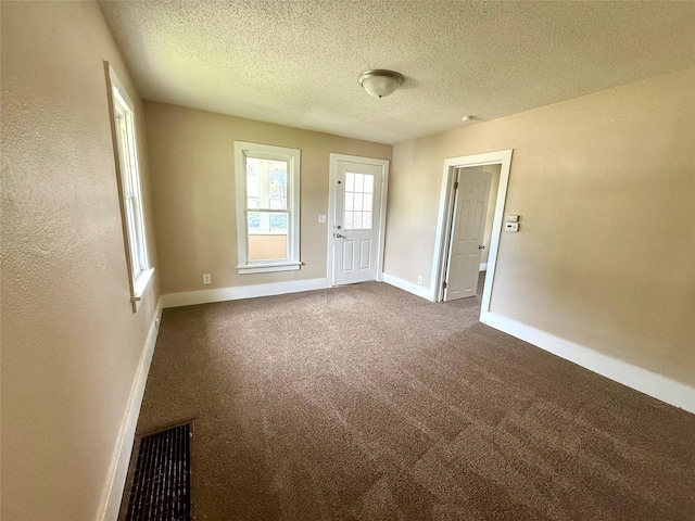 906 Rittenhouse St, Des Moines, IA 50315 - empty room with a textured ceiling and dark colored carpet