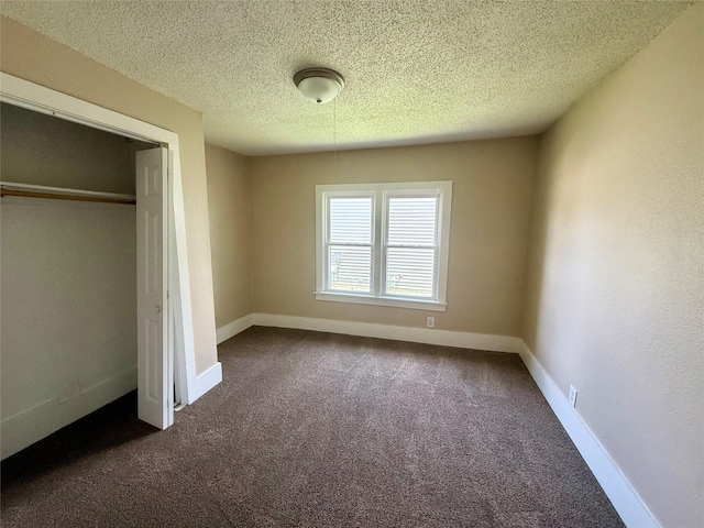 906 Rittenhouse St, Des Moines, IA 50315 - unfurnished bedroom featuring carpet floors, a textured ceiling, and a closet