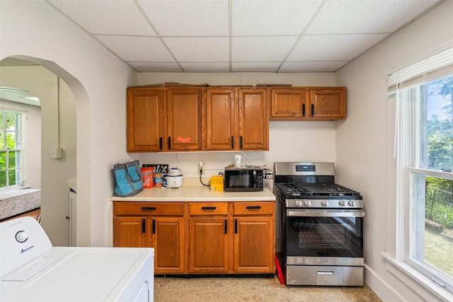 121 Cherry Ave, Ames, IA 50010 - kitchen featuring gas stove, washer / dryer, a drop ceiling, arched walkways, and brown cabinets