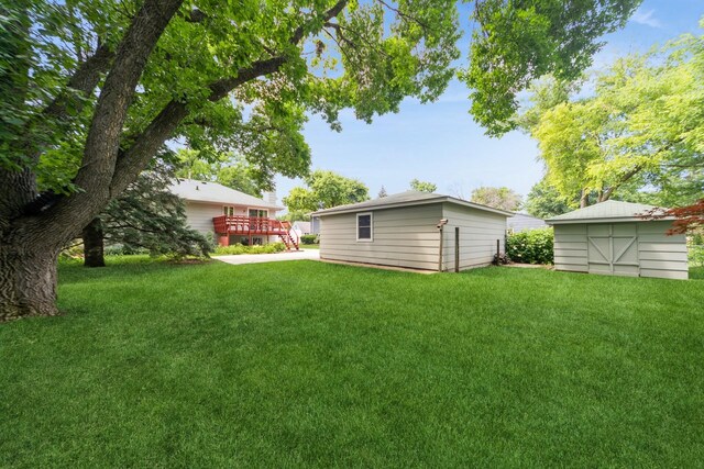 2424 Guenever Ct, Altoona, IA 50009 - view of green lawn with an outbuilding and a deck