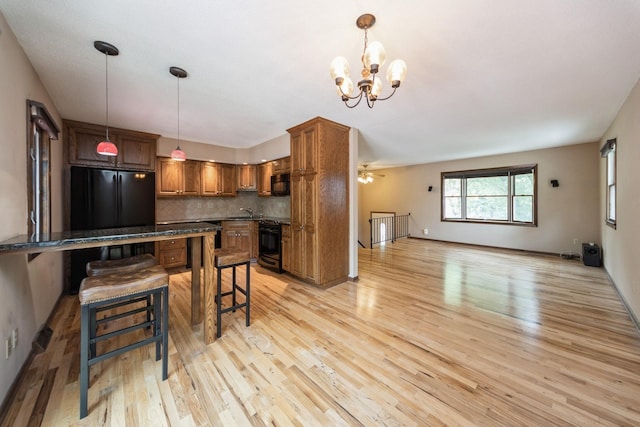 2424 Guenever Ct, Altoona, IA 50009 - kitchen with light wood-type flooring, brown cabinetry, a chandelier, a breakfast bar area, and tasteful backsplash
