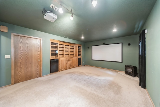 2424 Guenever Ct, Altoona, IA 50009 - home theater with carpet flooring, a wood stove, and a textured ceiling