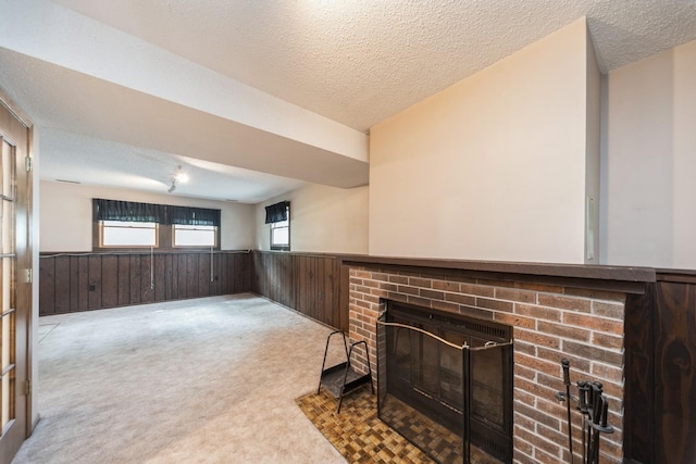 2424 Guenever Ct, Altoona, IA 50009 - unfurnished living room with wainscoting, a brick fireplace, wood walls, carpet, and a textured ceiling