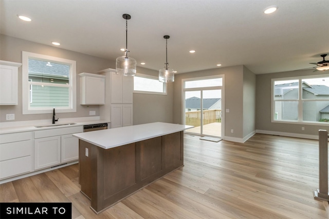 1435 Locust St, Waukee, IA 50263 - kitchen featuring light countertops, a center island, white cabinets, recessed lighting, and light wood-style flooring