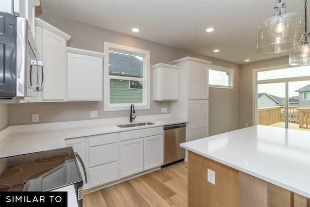 1435 Locust St, Waukee, IA 50263 - kitchen with stainless steel appliances, white cabinetry, light wood-type flooring, light countertops, and recessed lighting