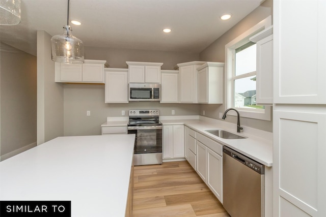 1435 Locust St, Waukee, IA 50263 - kitchen with stainless steel appliances, white cabinetry, decorative light fixtures, recessed lighting, and light wood finished floors