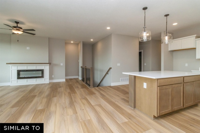 1435 Locust St, Waukee, IA 50263 - kitchen with light wood-style flooring, recessed lighting, open floor plan, a ceiling fan, and light countertops