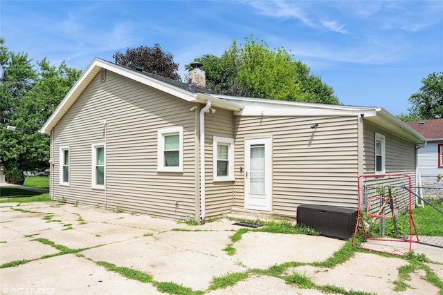 705 E Miller Ave, Des Moines, IA 50315 - back of property featuring a patio and a chimney