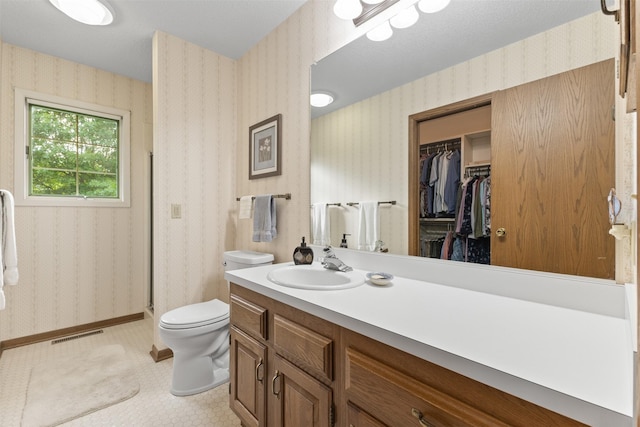2207 Buchanan Dr, Ames, IA 50010 - full bath with wallpapered walls, vanity, a walk in closet, and a shower