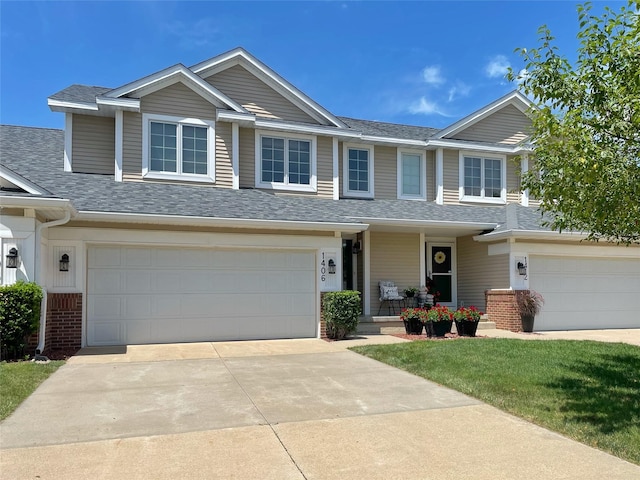 1406 SE Williams Ct, Waukee, IA 50263 - view of front of property with a garage, driveway, a shingled roof, a porch, and brick siding