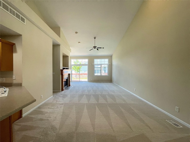 1406 SE Williams Ct, Waukee, IA 50263 - unfurnished living room with light colored carpet, a fireplace, a ceiling fan, and vaulted ceiling