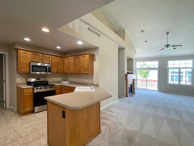 1406 SE Williams Ct, Waukee, IA 50263 - kitchen with stainless steel appliances, light countertops, a peninsula, recessed lighting, and open floor plan