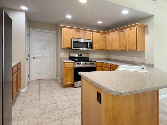 1406 SE Williams Ct, Waukee, IA 50263 - kitchen with stainless steel appliances, a peninsula, light countertops, and recessed lighting