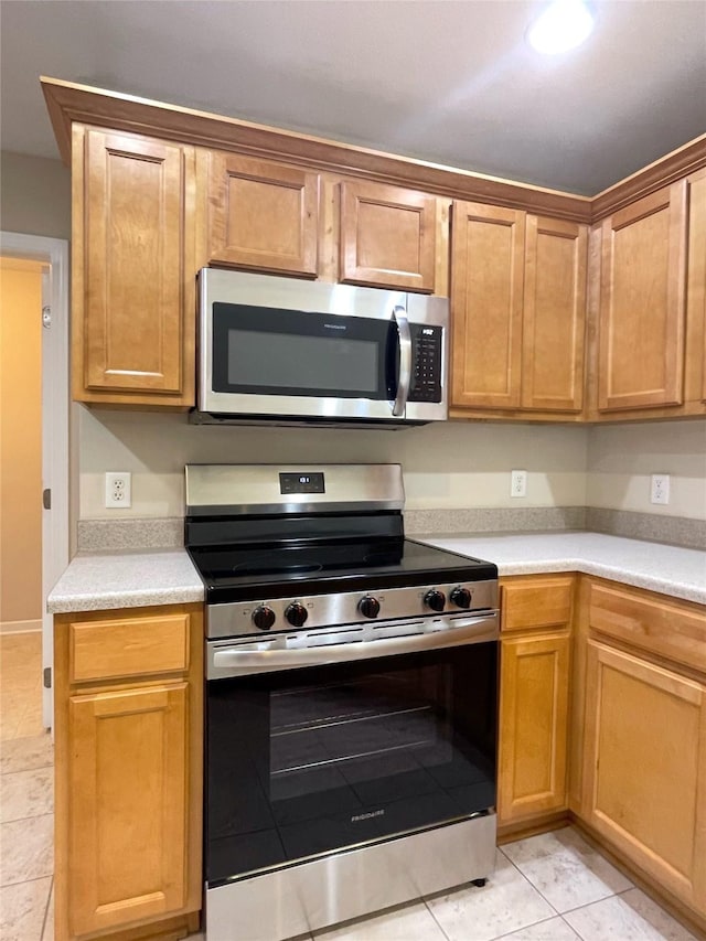 1406 SE Williams Ct, Waukee, IA 50263 - kitchen featuring stainless steel appliances, light countertops, and light tile patterned floors