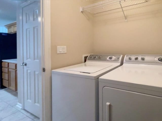 1406 SE Williams Ct, Waukee, IA 50263 - laundry room with washing machine and clothes dryer and light tile patterned floors