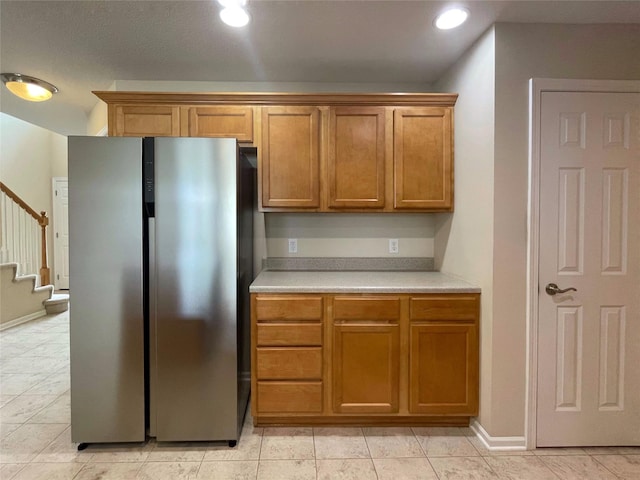 1406 SE Williams Ct, Waukee, IA 50263 - kitchen featuring freestanding refrigerator, light countertops, brown cabinetry, recessed lighting, and light tile patterned flooring